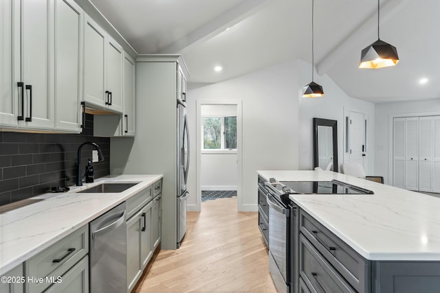 kitchen with pendant lighting, tasteful backsplash, sink, gray cabinetry, and stainless steel appliances