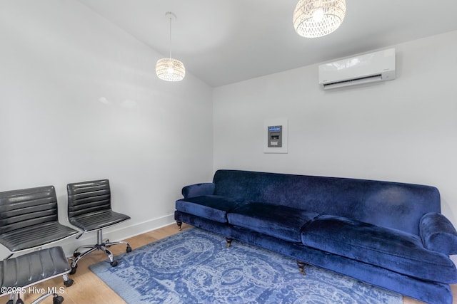 living room with hardwood / wood-style flooring, a wall mounted AC, and vaulted ceiling