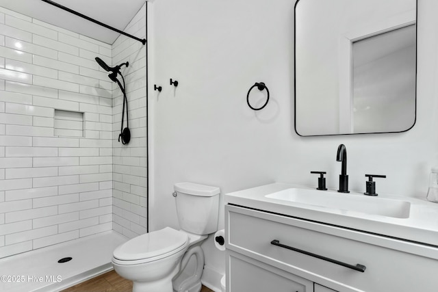 bathroom with vanity, hardwood / wood-style floors, toilet, and a tile shower