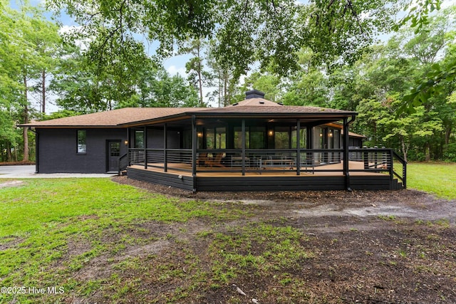 view of front of house with a sunroom and a front lawn