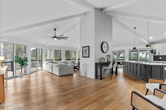 living room with lofted ceiling with beams, ceiling fan, and light hardwood / wood-style floors