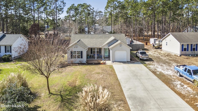 ranch-style house with covered porch, concrete driveway, a front lawn, and an attached garage