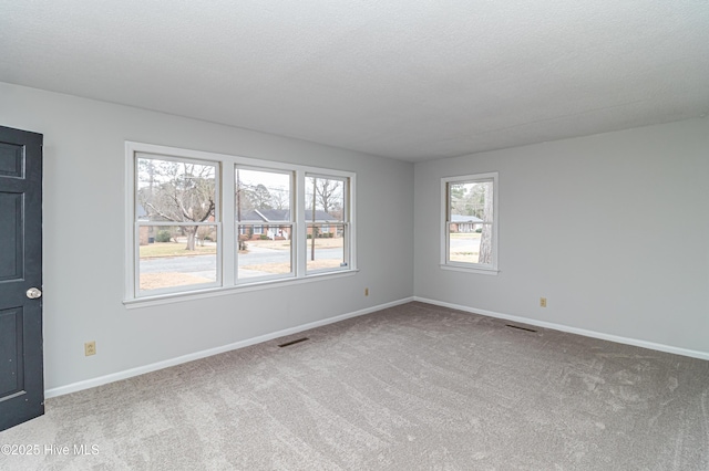 carpeted empty room with a textured ceiling