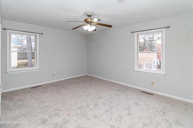 unfurnished room featuring ceiling fan, light carpet, and a textured ceiling