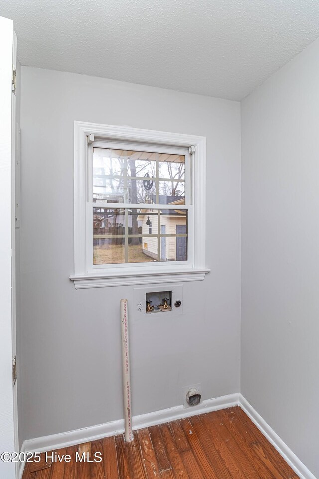 laundry room featuring hookup for a washing machine, dark hardwood / wood-style floors, hookup for an electric dryer, and a textured ceiling