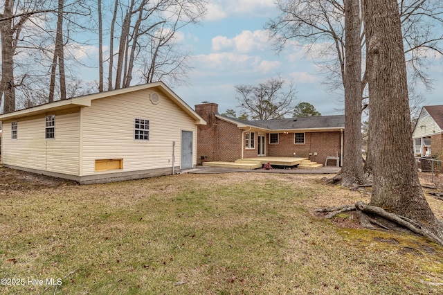 back of house featuring a wooden deck, a yard, and a patio area