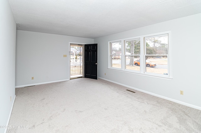 empty room featuring carpet flooring and a textured ceiling