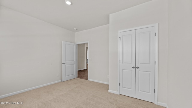 unfurnished bedroom featuring a closet and light carpet