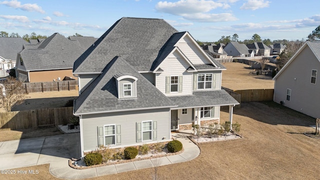 view of front of property featuring a residential view, fence, and a shingled roof