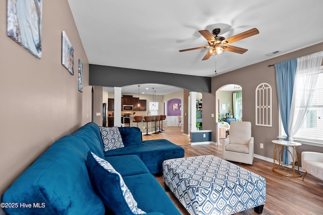300 William Sharp Way, Jacksonville, NC 28546 - living room featuring decorative columns, arched walkways, ceiling fan, light wood-type flooring, and baseboards