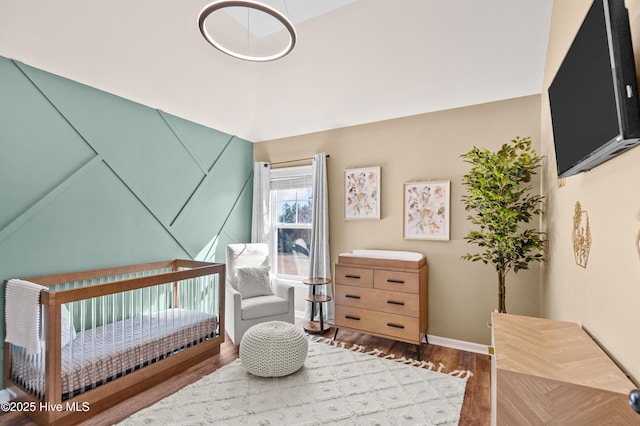 300 William Sharp Way, Jacksonville, NC 28546 - bedroom with wood finished floors, baseboards, a nursery area, and vaulted ceiling