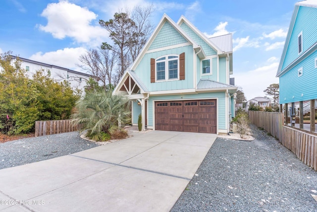 view of front of property featuring board and batten siding, an attached garage, fence, and concrete driveway