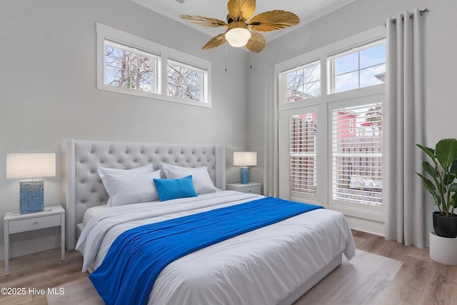 bedroom with multiple windows and light wood-style floors