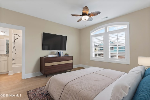 bedroom with connected bathroom, visible vents, baseboards, and light wood-style flooring