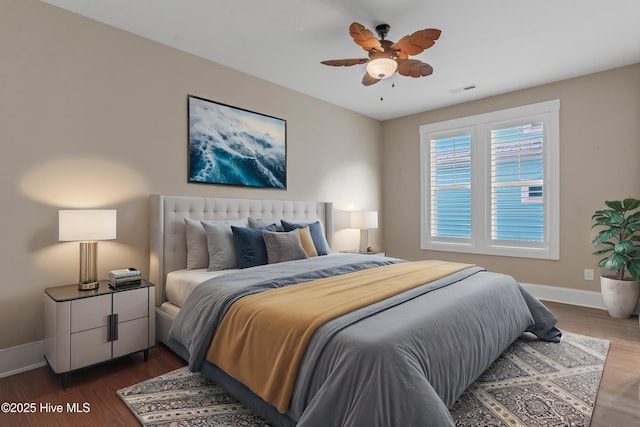 bedroom with visible vents, baseboards, and wood finished floors