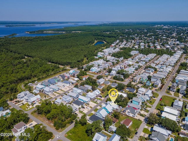 drone / aerial view featuring a forest view, a water view, and a residential view