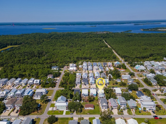 drone / aerial view with a residential view, a wooded view, and a water view