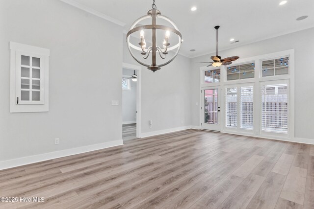 spare room featuring ceiling fan with notable chandelier, light wood-style floors, baseboards, and ornamental molding