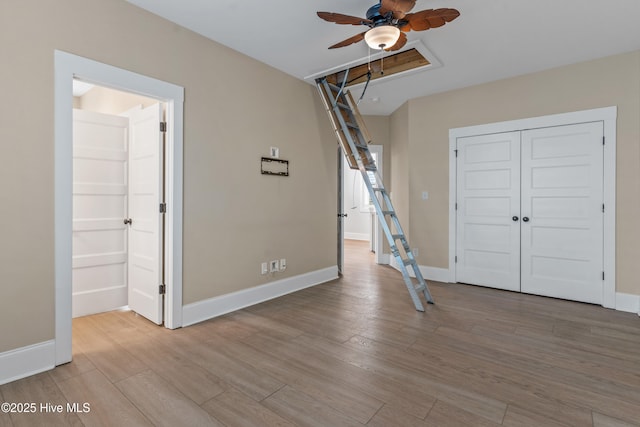 interior space featuring light wood-style flooring, baseboards, a closet, and ceiling fan