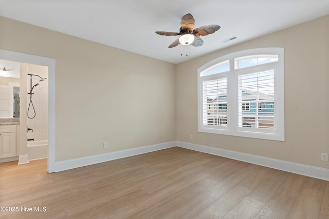 empty room with visible vents, baseboards, a ceiling fan, and light wood finished floors