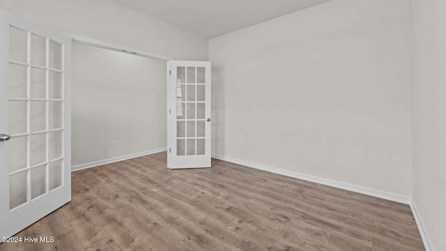 empty room with light wood-type flooring and french doors