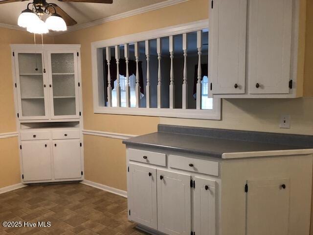 kitchen with white cabinetry, ceiling fan, and crown molding