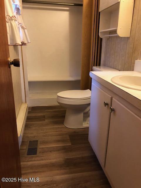 bathroom featuring vanity, wood-type flooring, and toilet