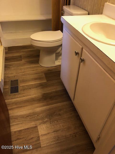 bathroom featuring vanity, wood-type flooring, and toilet