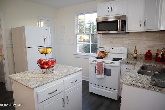 kitchen with sink, white appliances, white cabinets, and backsplash