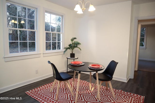 dining space with dark wood-type flooring and a chandelier