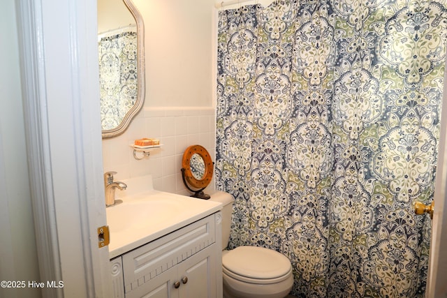 bathroom featuring tile walls, vanity, and toilet