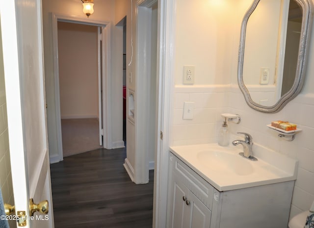 bathroom with hardwood / wood-style flooring, vanity, and tile walls