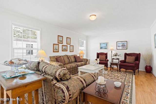 living room with crown molding, light wood-type flooring, and a wealth of natural light