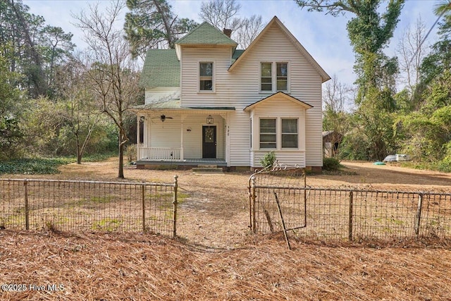 victorian home with a porch, a gate, and a fenced front yard