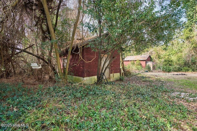 view of yard with an outbuilding and a shed