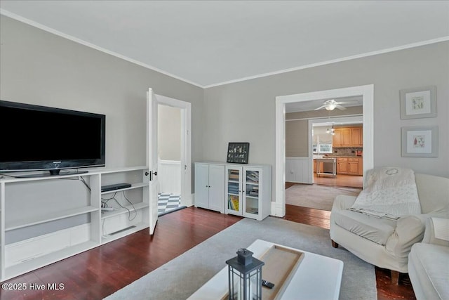 living area featuring ornamental molding and wood finished floors