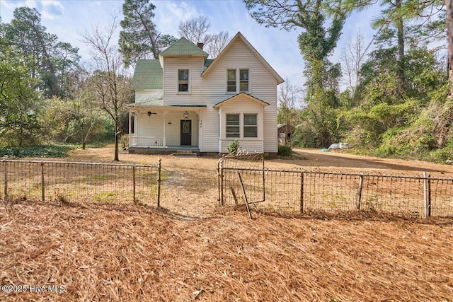 back of property with a fenced front yard and a porch