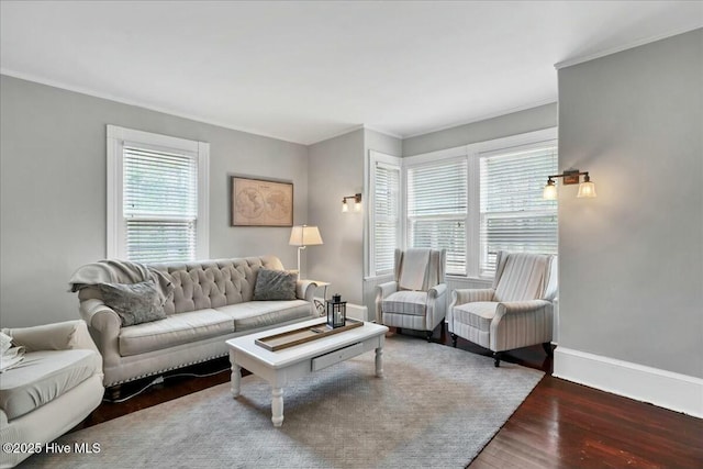 living room featuring crown molding, baseboards, and wood finished floors