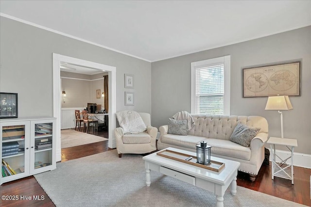 living area featuring ornamental molding, wood finished floors, and baseboards