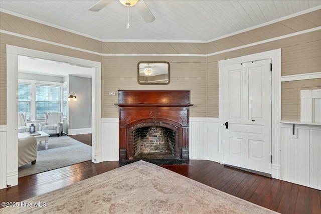 living room with a fireplace with flush hearth, wood-type flooring, and crown molding