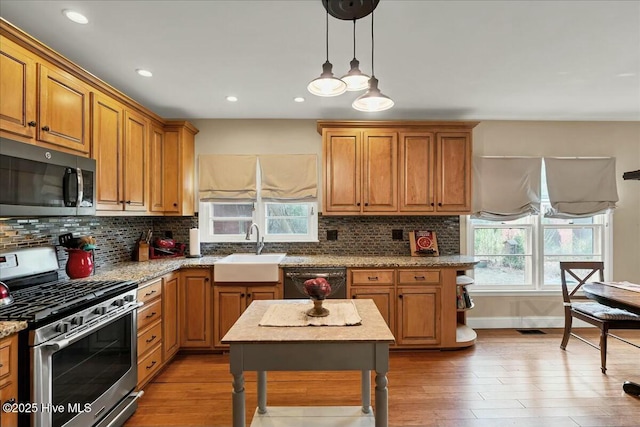 kitchen with dishwasher, a sink, gas range, and decorative backsplash