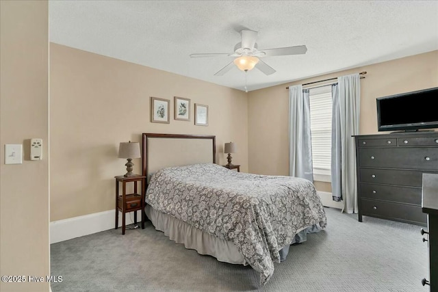 bedroom featuring light carpet, a textured ceiling, and baseboards