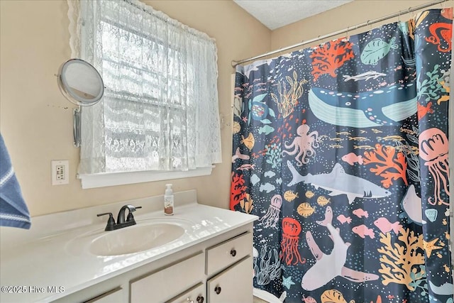 bathroom featuring a shower with shower curtain, a wealth of natural light, and vanity