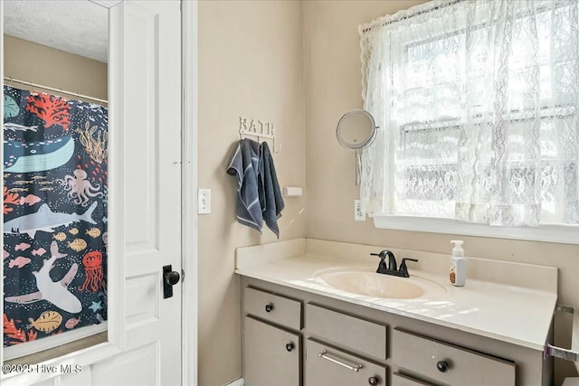 full bath featuring a textured ceiling and vanity