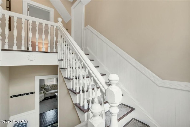 stairway featuring wainscoting