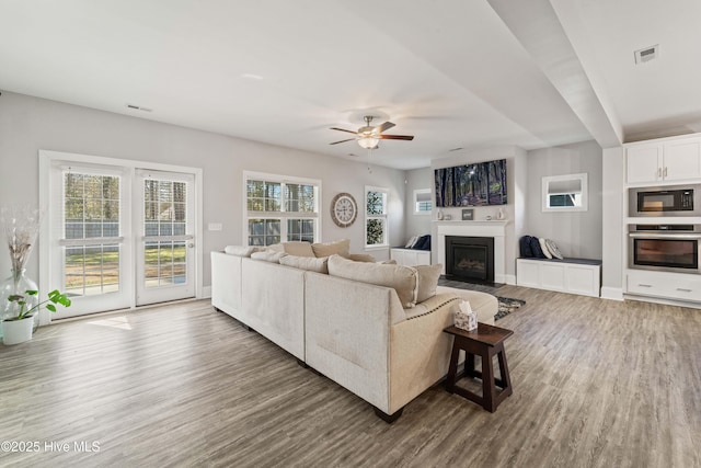 living room with dark hardwood / wood-style flooring and ceiling fan