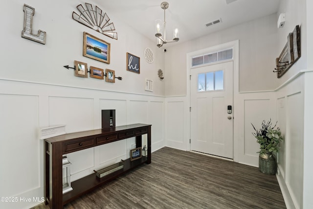 foyer entrance with dark hardwood / wood-style flooring and a notable chandelier