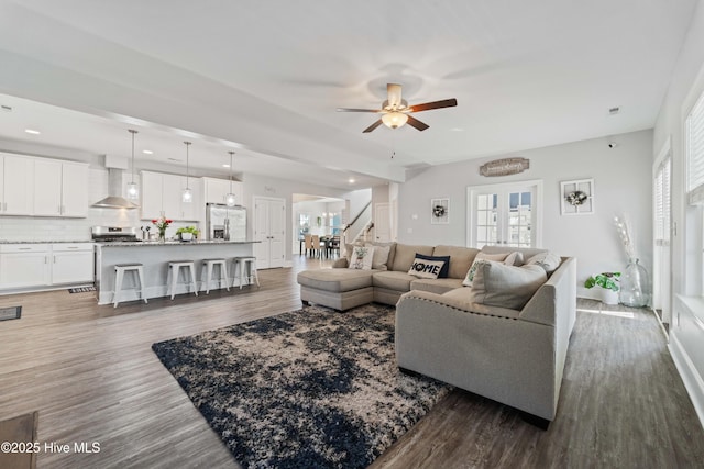 living room featuring dark wood-type flooring, ceiling fan, and french doors