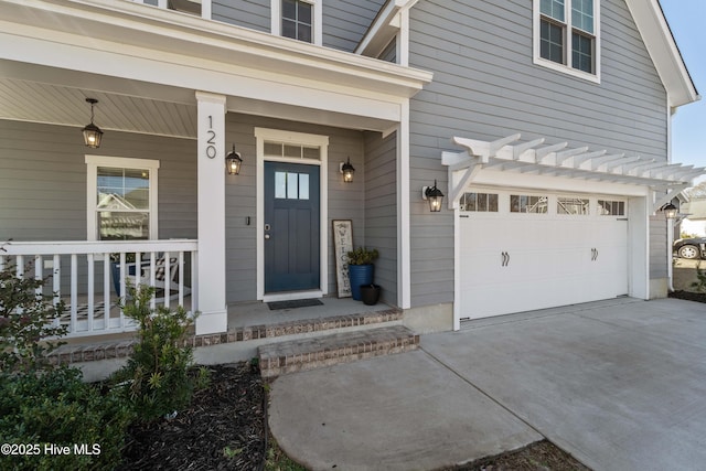 view of exterior entry featuring a garage and a porch