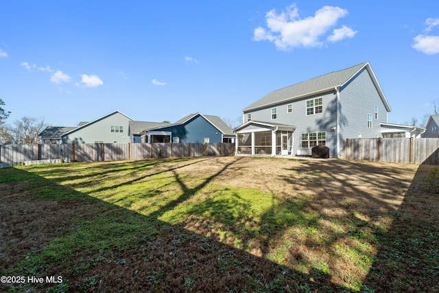 rear view of property featuring a lawn and a sunroom